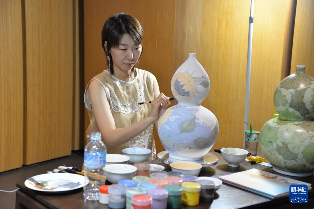 7月2日,一位女士在日本大阪世博会中国馆江西活动日上展示景德镇手工制瓷技艺。新华社记者 涂一帆 摄