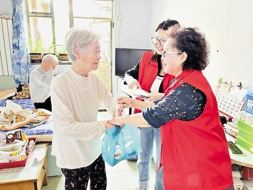 近日，在燕山路街道新城社区，“老帮老”志愿者为社区老人送上亲手包的粽子。 宋昕蔚摄