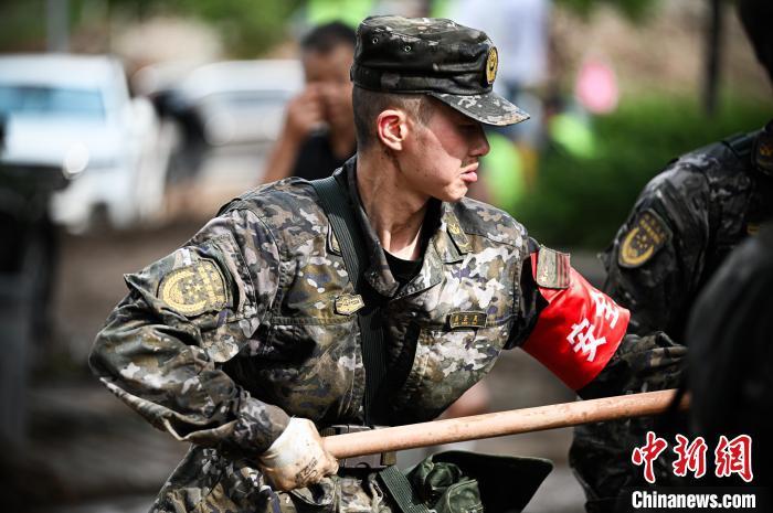 图为武警商洛支队官兵利用铁锹清理道路淤泥。徐宝帅 摄