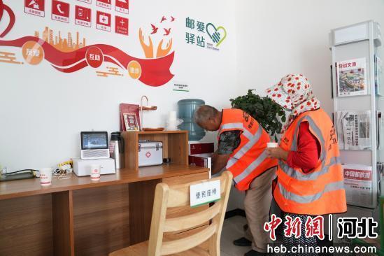 图为环卫工人在驿站内使用便民饮水点。 董树科 摄