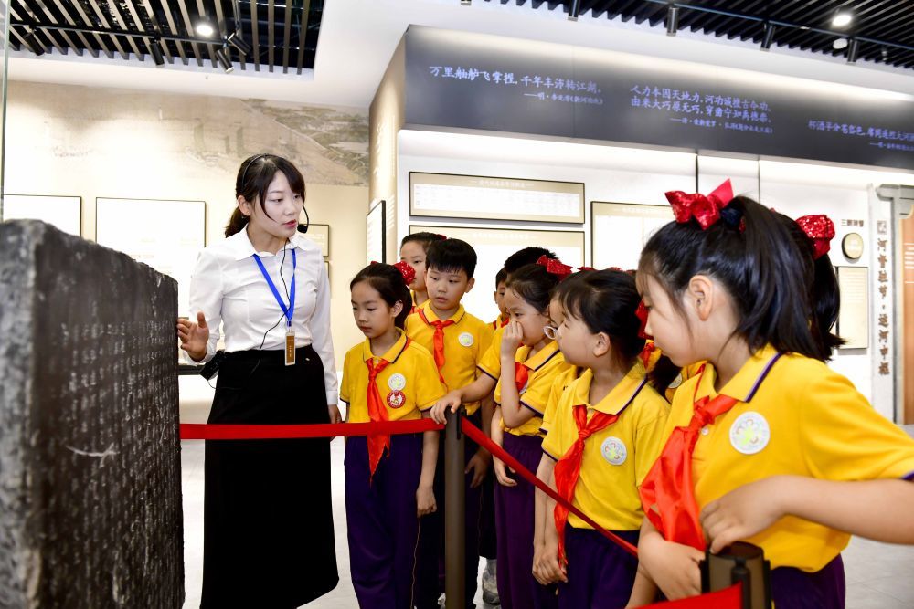 在山东省济宁市的河道总督署遗址公园展馆，讲解员为小学生讲解运河文化（2025年6月6日摄）。元明清河道总督署驻扎济宁，负责管理京杭运河及相关河道。2024年，河道总督署遗址公园建成并免费向社会开放，对促进京杭运河文化的保护传承和利用有积极意义。