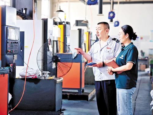 7月1日，沧县税务局税务工作人员（左）入企问需。 本报记者袁铮摄