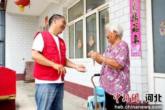 图为7月10日，河北省隆尧县山口镇北潘庄村，志愿者免费为老人送鲜奶。 张冬茹 摄