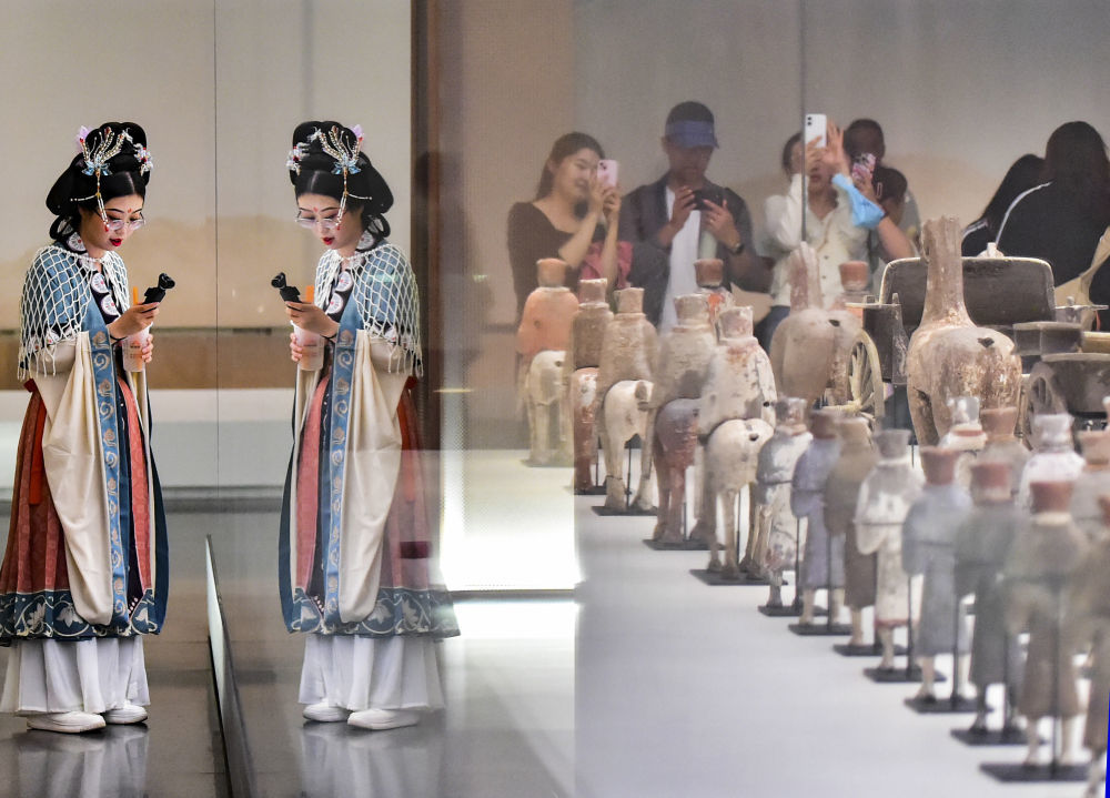 游客在山东省青州博物馆拍摄展出的文物，近距离感受历史和文化的魅力（2025年5月17日摄）。