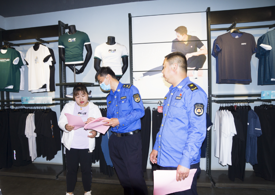 虞城縣城管隊員（著制服者）在宣傳講解“門前五包”有關規定 賈震 攝