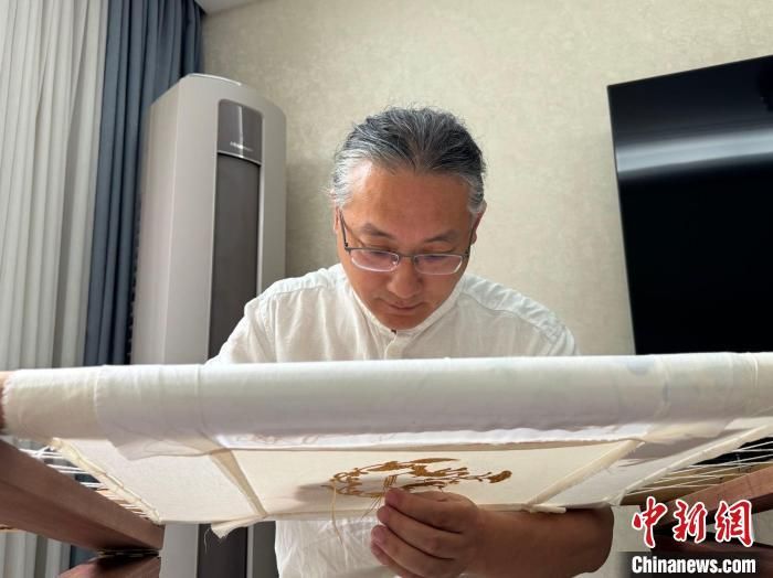 6月27日，张欣在家中绣制作品。杨英琦 摄