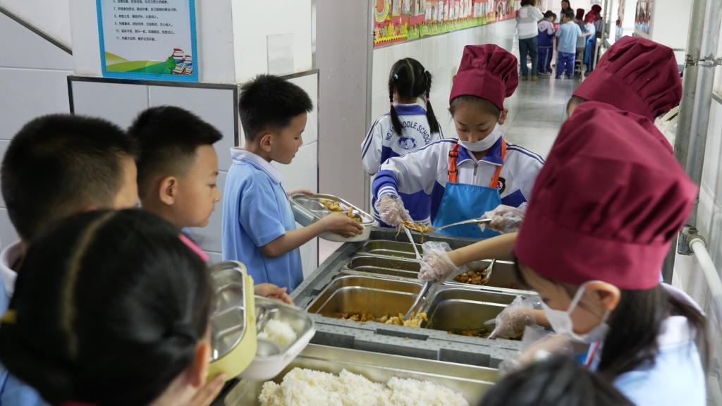 长春市南关区第一〇三中学校小学部教学楼走廊内，学生们正在参与分餐。新华社记者 张文嵘 摄
