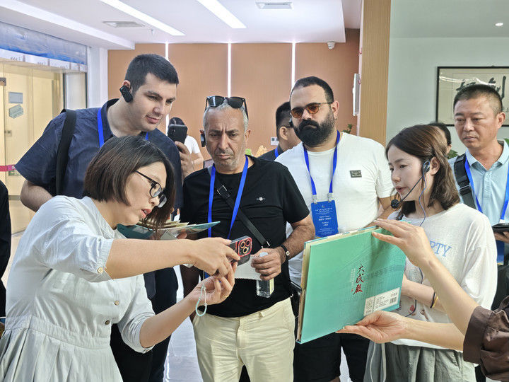 7月7日,在山东济宁的一家动漫公司内,工作人员向参加全球文明对话部长级会议的嘉宾介绍文创产品。新华社记者 高天 摄