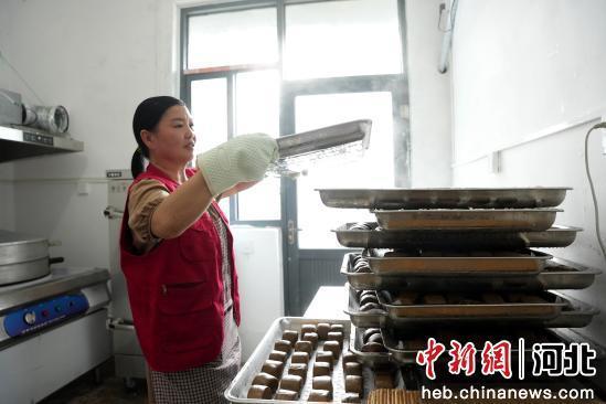 图为7月10日，河北省隆尧县山口镇北潘庄村村委会敬老食堂，志愿者在制作馒头。 张冬茹 摄