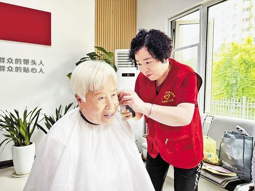 6月30日，在太平路街道中建城二社区，“老帮老”志愿者为社区老人义务理发。 常 磊摄