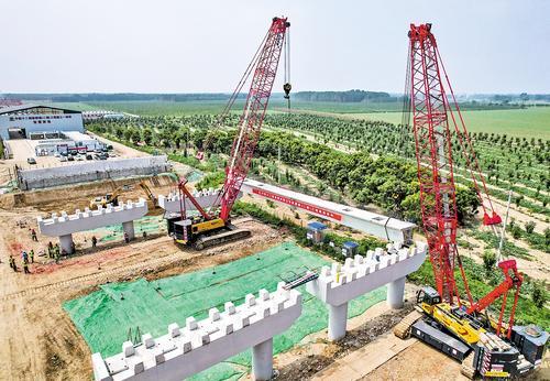 7月10日10时许，雄安新区雄鄚路二期工程燕南长城大桥首片箱梁正在架设。 本报记者 李东宇摄