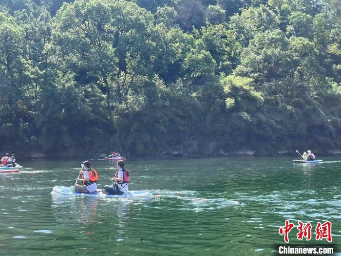 7月5日，“2025靖安首屆槳板潮玩季”活動在江西省靖安縣陳家畬文旅綜合體開幕，游客在清澈的小溪上體驗槳板運動。王劍/攝
