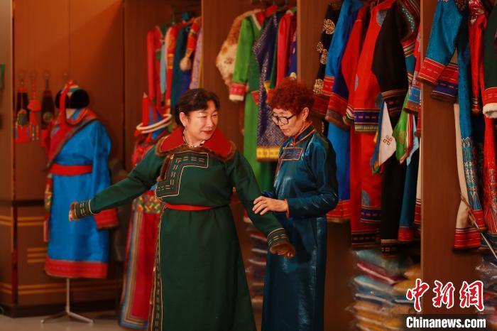 图为娜仁其其格正在为游客量体裁衣 陈坤 摄