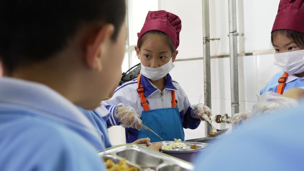 长春市南关区第一〇三中学校小学部教学楼走廊内，学生们正在参与分餐。新华社记者 张文嵘 摄