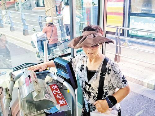7月6日，一位老人正在刷手乘坐公交车。 本报记者 陈宝云摄