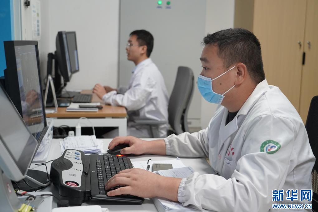 遂川县人民医院影像共享中心工作人员正在为患者进行检查。新华网发