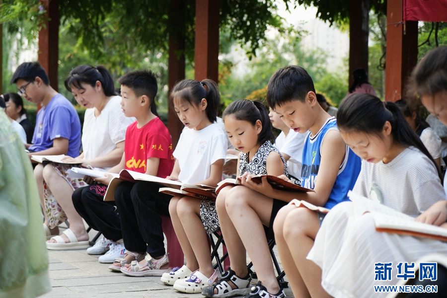 7月8日，在河南方城縣竹林廣場暑期晨讀點，閱讀愛好者正在閱讀經典書籍。