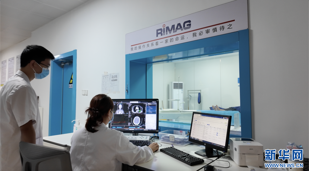 遂川县人民医院影像共享中心工作人员正在为患者进行检查。新华网发