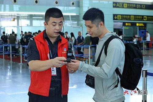 南昌昌北国际机场工作人员为旅客检查充电宝是否合规。