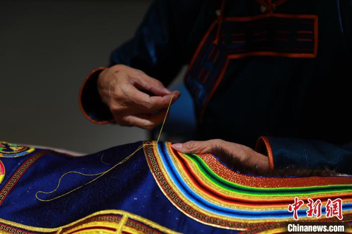 图为娜仁其其格正在手工缝制传统蒙古族服饰 陈坤 摄