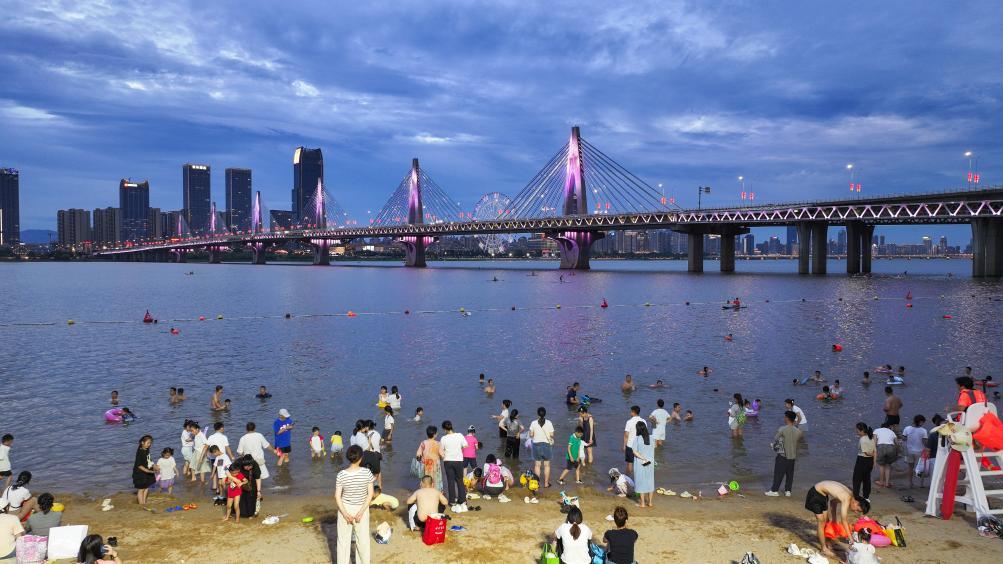 市民们在位于南昌市西湖区的万紫·千红滩天然泳场游玩。新华社发（郭建美 摄）