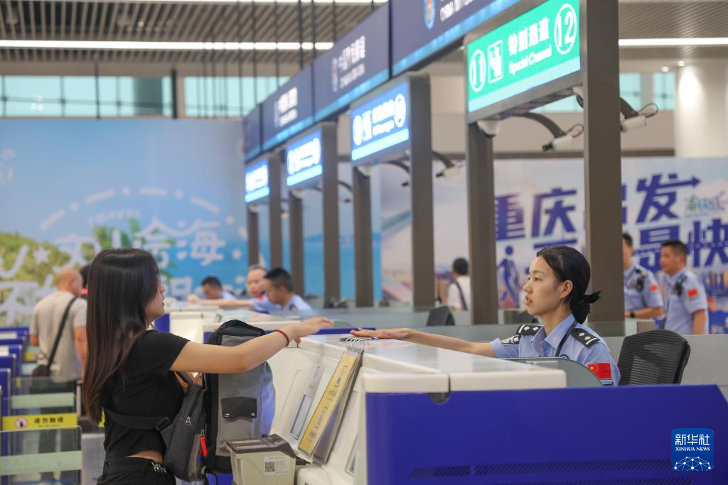 7月8日,在重庆江北国际机场,重庆出入境边防检查总站民警查验旅客信息。新华社记者 黄伟 摄