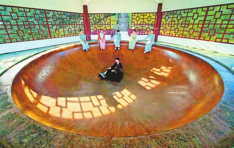 7月10日，游客在义门陈文化产业园一景点前留影。　　特约通讯员 邓龙华摄