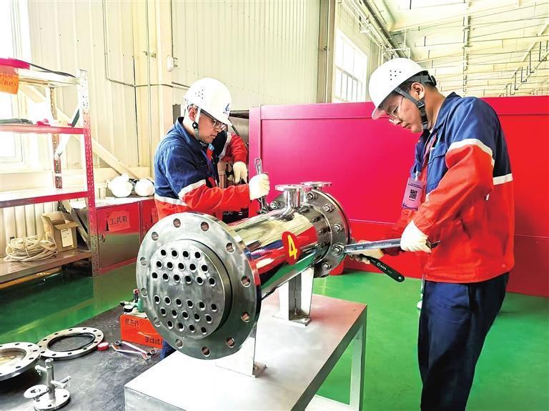 7月14日，甘肃省百万职工劳动和技能竞赛第三届全省化工行业职工职业技能大赛在兰州新区化工园区安全技能实训基地正式开赛，共有35家单位150余名职工参赛。图为参赛选手在进行列管式换热器拆卸。兰州新区报记者　霍鸿宇　摄