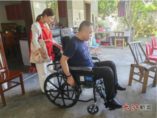 社工小胡带彭叔叔试新轮椅。(信州区融媒体中心供图)