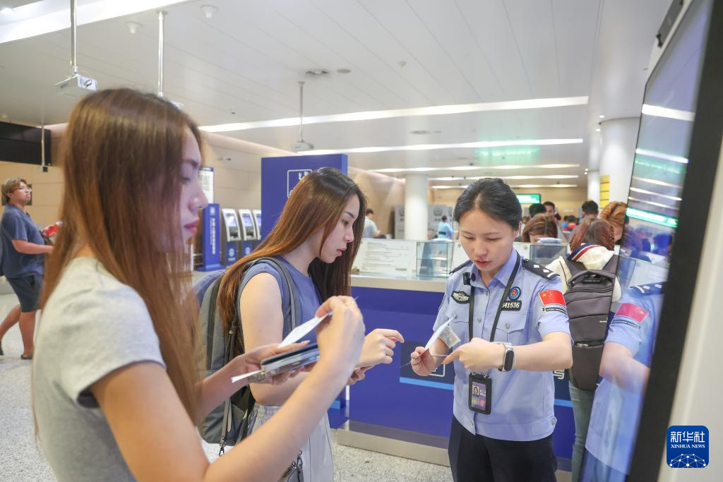 7月8日,在重庆江北国际机场,重庆出入境边防检查总站民警解答入境旅客疑问。新华社记者 黄伟 摄