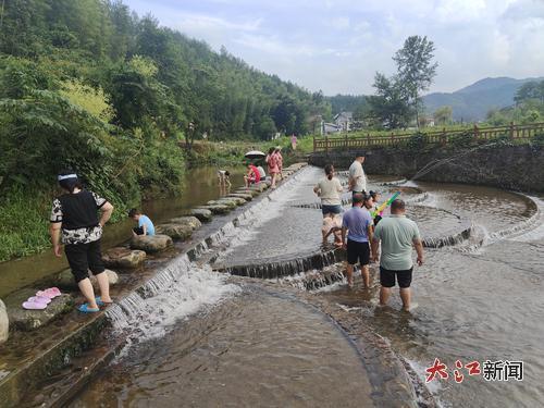 7月15日，游客在中源鄉玩水。