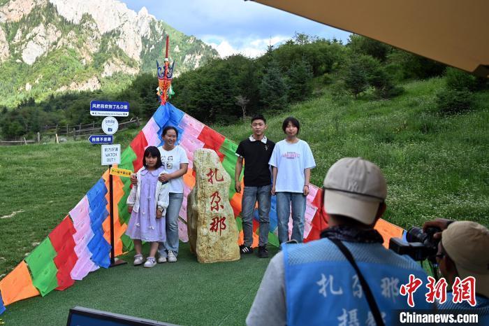图为游客在扎尕那景区拍照游览　中新社记者　九美旦增　摄
