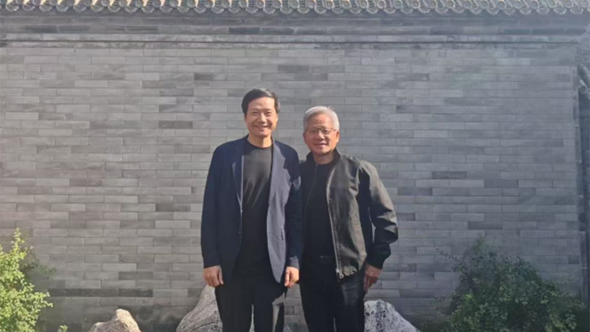 黄仁勋年内第三次访华，高温下身穿标志性皮衣与雷军微笑合影