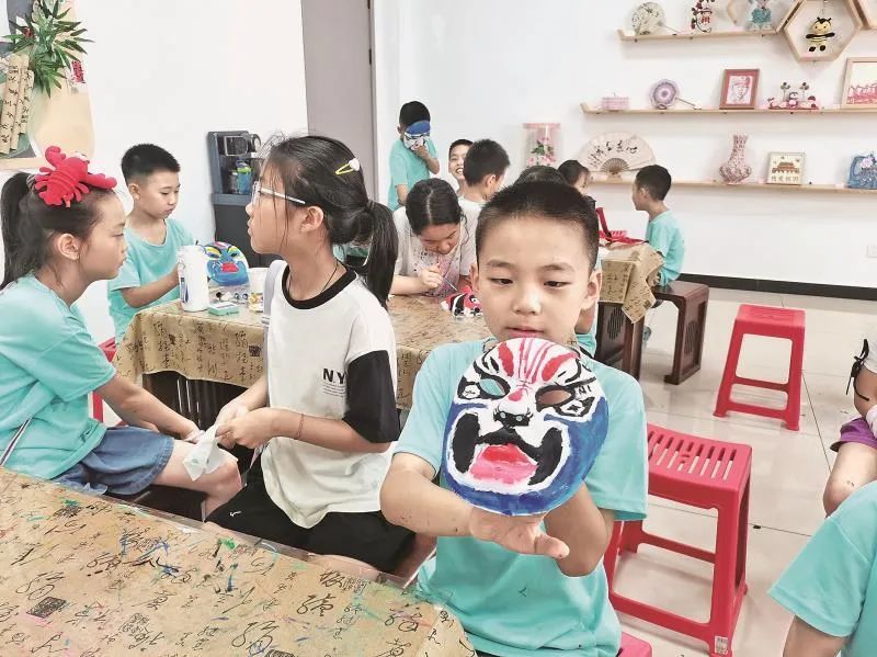 绣园社区非遗脸谱课堂上，小朋友展示彩绘脸谱