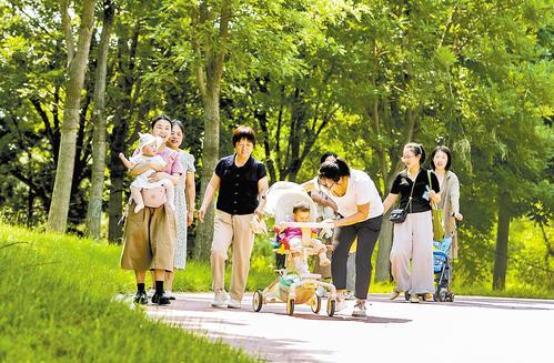 7月13日，雄安新区启动区中央绿谷公园内，来自雄安新区启动区疏解单位的工作人员带着孩子在家门口的公园游园赏景。 刘光昱摄