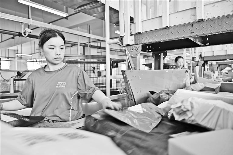7月11日，中通快递上饶转运中心工作人员在智能分拣线上进行包裹分拣。　　本报全媒体记者 王蕴蓉摄
