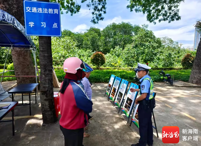交警向市民讲解电动车遮阳伞危害。三亚交警供图