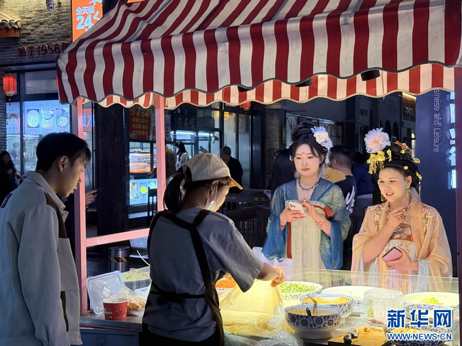 7月10日，游客在洛阳市西工小街选购美食。