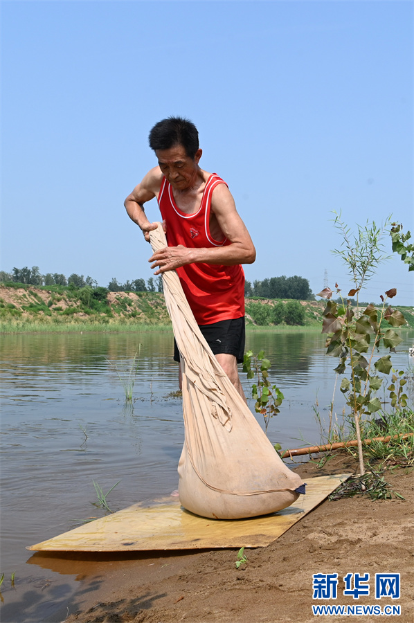 7月14日，河南省沁阳市西向镇东高村，东高高氏古法造纸技艺传承人在展示“捞纸”技艺——拧穰。