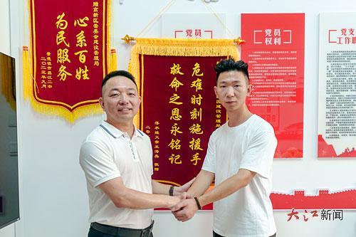 获救男孩家长向陈鹏(图左)送上锦旗。