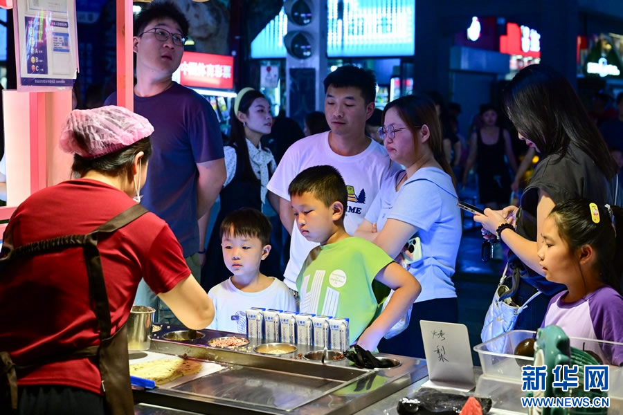 7月10日，游客在洛阳市西工小街选购美食。