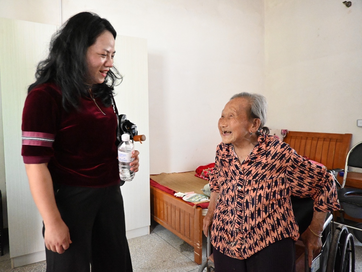 图为带队老师正在与老人交流