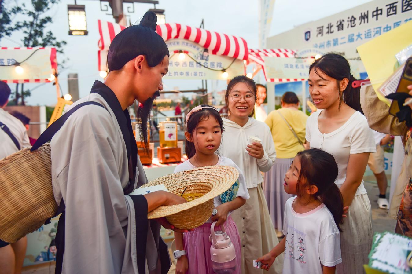 “老药师”向参加活动的孩子与家长讲解中医药文化。
