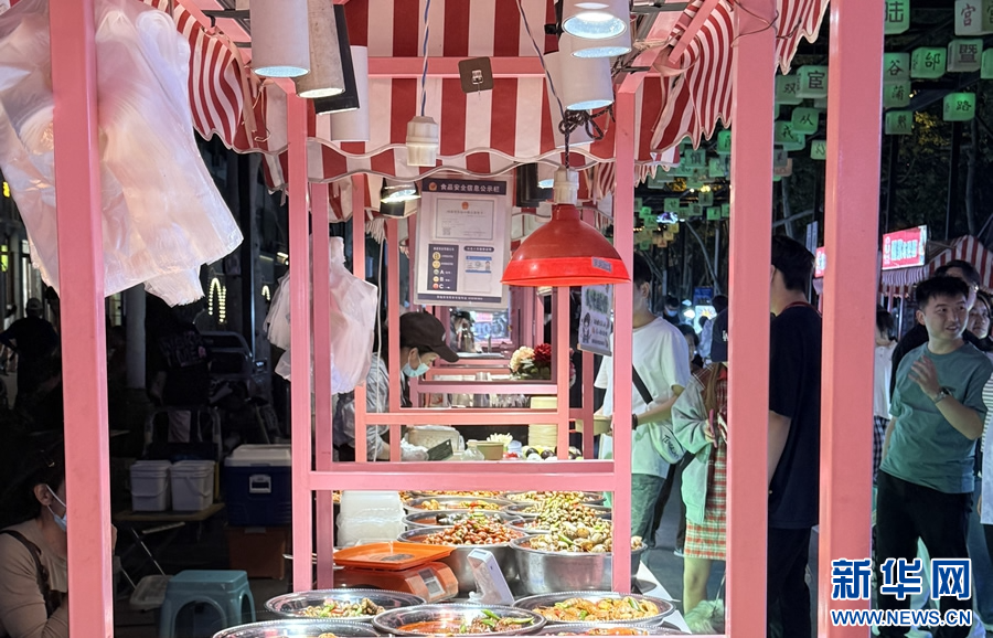 7月10日，游客在洛阳市西工小街选购美食。