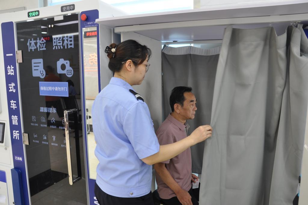 渔山派出所工作人员指导办事群众使用人像采集系统。（受访单位供图）