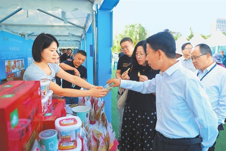 与会嘉宾在农产品专区与参展商进行交流