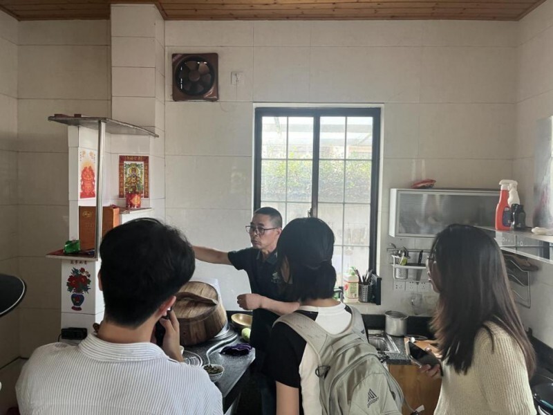 图为团队成员深入村民家中参观灶头画