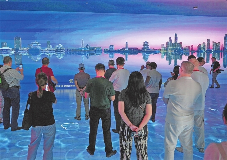 7月15日,九江市国土空间规划馆,外媒嘉宾正在观看九江市宣传片。张玉丰摄