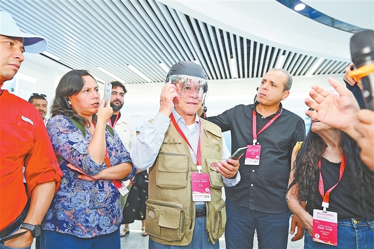 7月15日,在南昌高新区晶能光电股份有限公司,外媒嘉宾饶有兴致地体验一款能导航、能打电话的“外卖员头盔”。江西日报全媒体记者 吴文兵摄