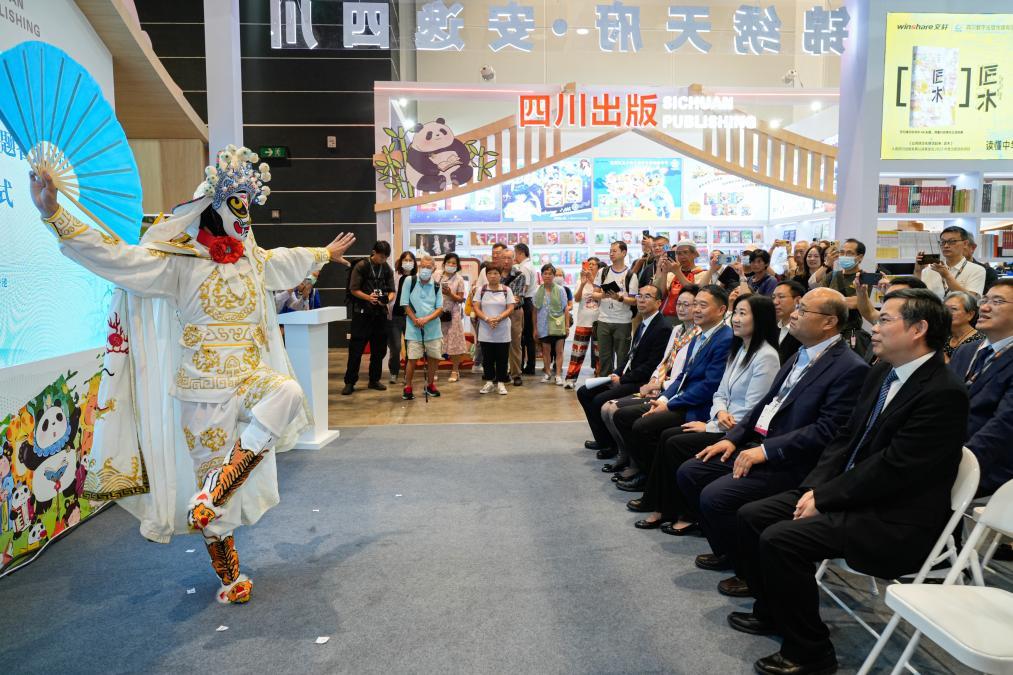 7月16日，参观者在第35届香港书展上观看川剧变脸表演。新华社供图